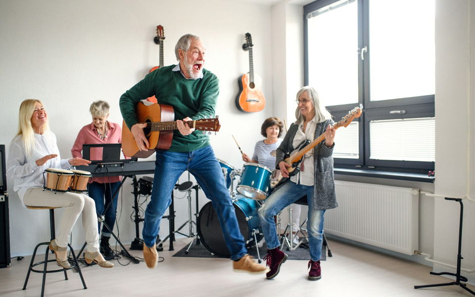 Des seniors profitant d'un cours de musique, chacun avec son instrument, souriants et concentrés