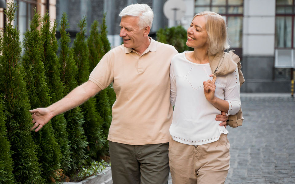 Deux couples de seniors marchant ensemble dans la rue, profitant d'une promenade en plein air.