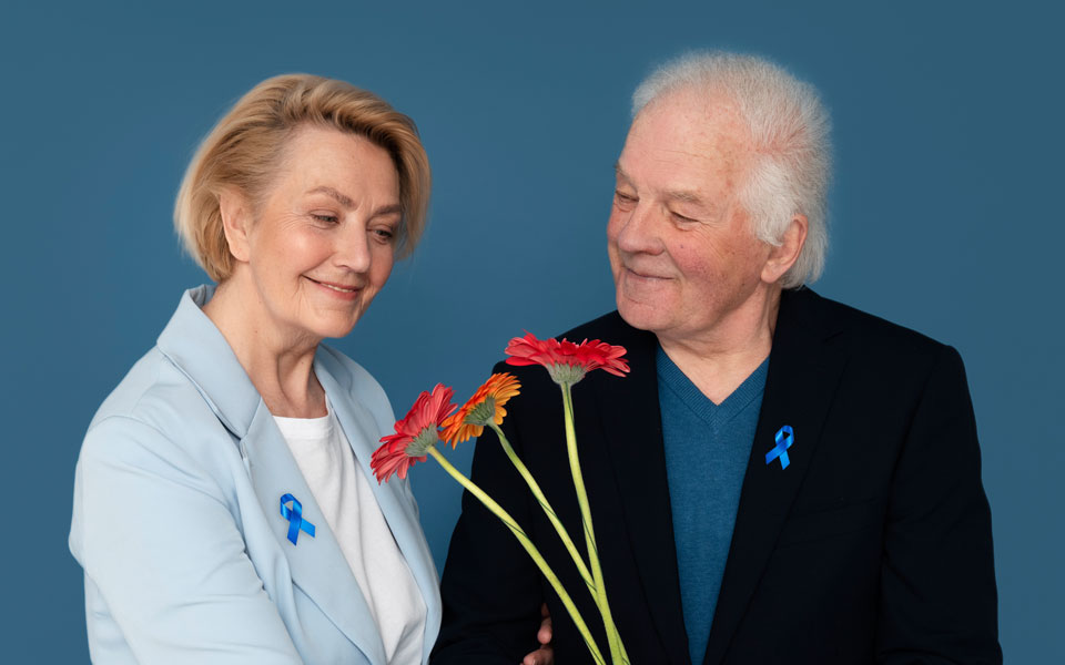 Deux couples seniors participant à Mars Bleu, tenant des bouquets de fleurs, symbolisant la sensibilisation au cancer colorectal