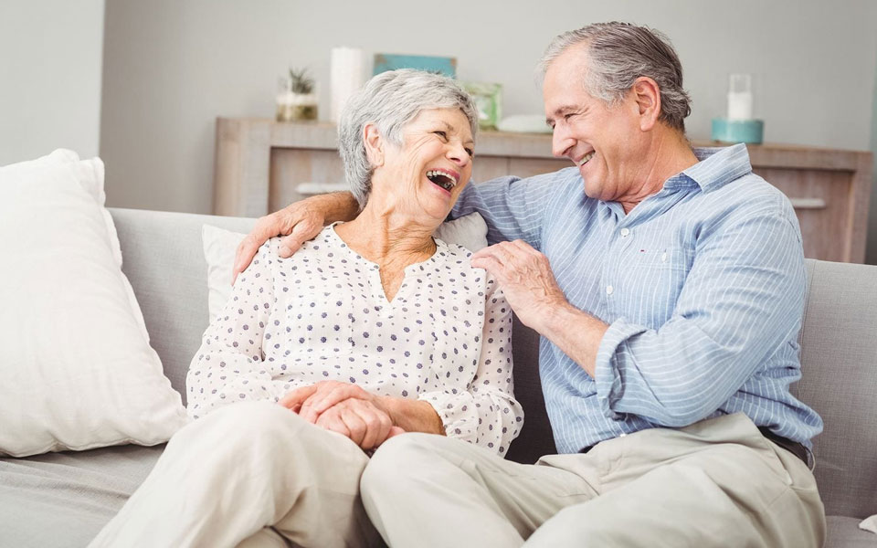 Deux couples seniors souriants se soutenant mutuellement, symbolisant l'entraide et l'amitié. 