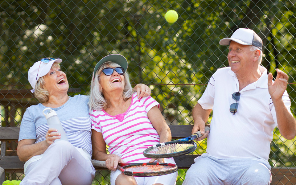 Trois seniors heureux portant une tenue de tennis