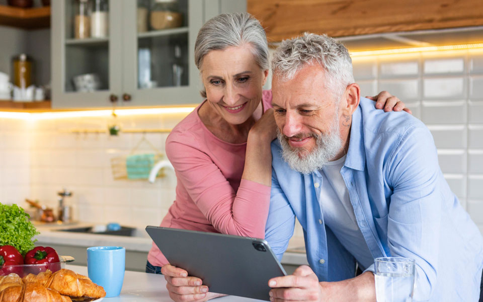 Deux couples seniors utilisant une tablette ensemble