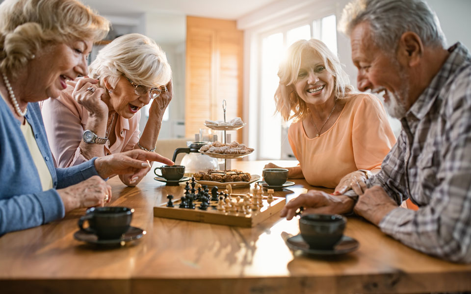 Groupe de retraités l'air heureux jouant aux échecs