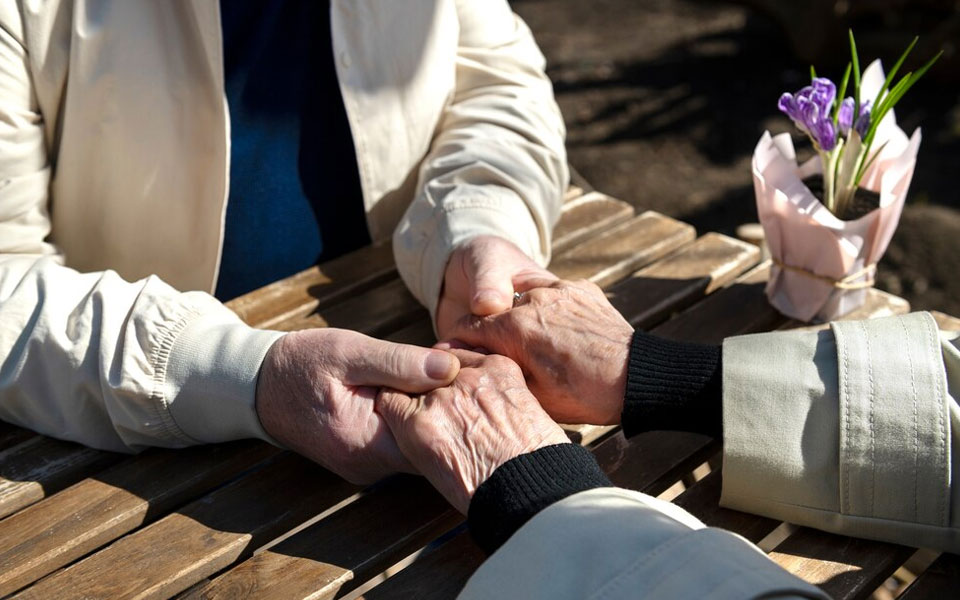 Deux seniors se tenant par la main, symbolisant la solidarité et l'amour intergénérationnel.